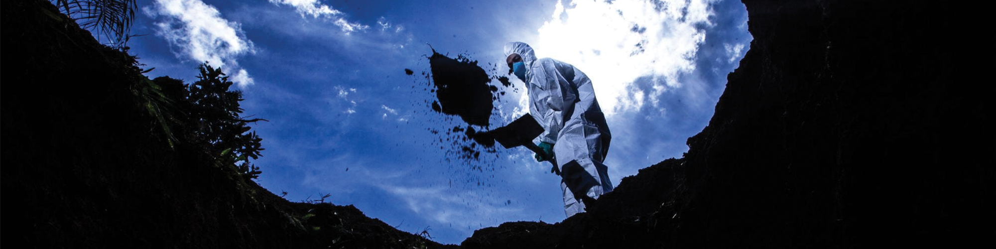 man shoveling dirt into a hole